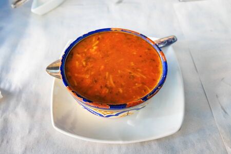 Moroccan Harira Soup in white bowl in one of the restaurants in Morocco.