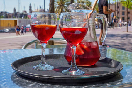 Jug and glasses with sangria beverage on the table in street cafe in center of Barcelona. Spain.の写真素材