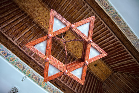 FEZ, MOROCCO - JUNE 02, 2017: Wooden chandelier in the Dar Batha. The former royal palace, was built...