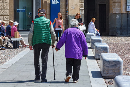 BERGAMO, ITALY - MAY 22, 2019: Unknown elderly people walking in Upper Bergamo (Citta Alta) in northern Italy. Bergamo is a city in the alpine Lombardy region.のeditorial素材