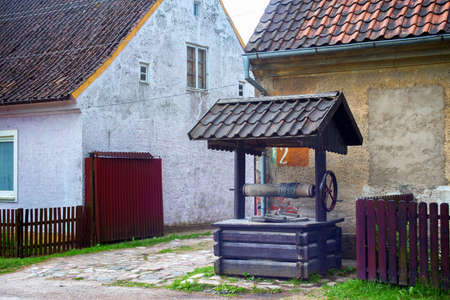 KRASNOLESYE, RUSSIA - JUNE 12, 2016: View of the wooden well and the old historical German buildings in the village of Krasnolesye (former Gross-Rominten) in the Kaliningrad region, Russiaのeditorial素材