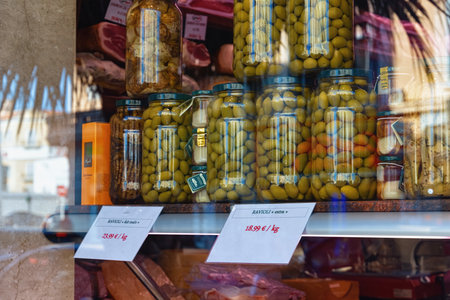 CANNES, FRANCE - JUNE 19, 2017: View of the green pickled olives in the glass bottles in the showcase of the one of town stores.のeditorial素材