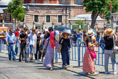 ISTANBUL, TURKEY - JULY 05, 2018: Group of unknown tourists with famous buildings of the Holy Hagia...
