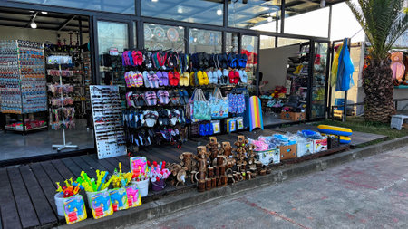BATUMI, GEORGIA - JUNE 25, 2023: Sale of things for swim, sandals and various souvenirs in Batumi marina in city center resort on the Black sea.のeditorial素材