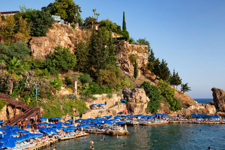 ANTALYA, TURKEY - JULY 08, 2018: Unknown people resting on the famous Mermerli beach (in historical part of city - Kaleici) in Antalya.のeditorial素材