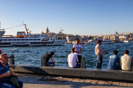ISTANBUL, TURKEY - JULY 06, 2018: Unknown people with a rods is fishing in the Bosphorus near the Galata Bridge.のeditorial素材