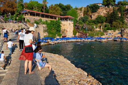 ANTALYA, TURKEY - JULY 08, 2018: Unknown people resting on the famous Mermerli beach (in historical part of city - Kaleici) in Antalya.のeditorial素材