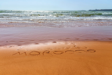 Morocco word is written on the sandy beach of the Atlantic ocean coast in Morocco.の写真素材