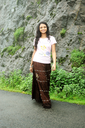 KODAIKANAL, INDIA - JUNE 30TH, 2015: A happy woman walking on a path on a mountainのeditorial素材