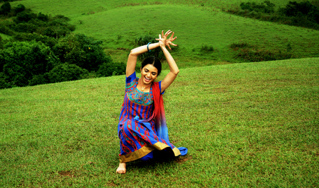 KODAIKANAL, INDIA - JUNE 30TH, 2015: Young woman dancing on the hillのeditorial素材