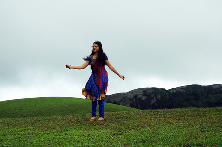 KODAIKANAL, INDIA - JUNE 30TH, 2015: Young woman dancing on the hillのeditorial素材