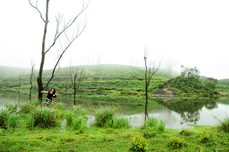 KODAIKANAL, INDIA - JUNE 30TH, 2015: A girl raised her hands. Happiness and freedom in mountainsのeditorial素材