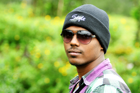 KODAIKANAL, INDIA - JUNE 30TH, 2015: Portrait of a handsome young man in sunglasses on posing outdoorのeditorial素材