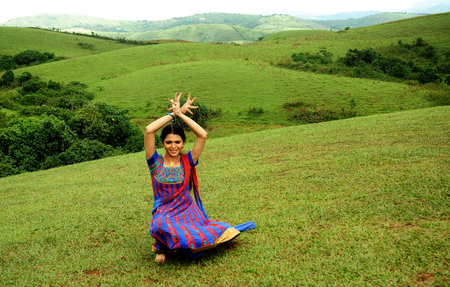KODAIKANAL, INDIA - JUNE 30TH, 2015: Young woman dancing on the hillのeditorial素材