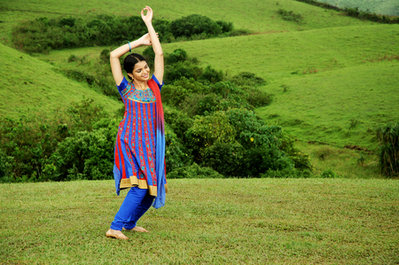 KODAIKANAL, INDIA - JUNE 30TH, 2015: Young woman dancing on the hillのeditorial素材