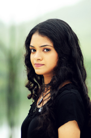 KODAIKANAL, INDIA - 30 JUNE, 2015: Cute young woman looking at cameraのeditorial素材
