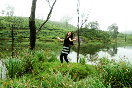 OOTY, INDIA - 30 JUNE, 2015: A girl raised her hands. Happiness and freedom in mountainsのeditorial素材