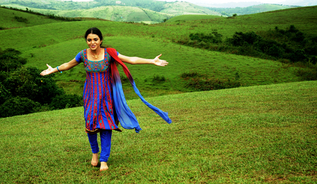 KODAIKANAL, INDIA - JUNE 30TH, 2015: Young woman dancing on the hillのeditorial素材