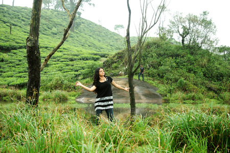 OOTY, INDIA - 30 JUNE, 2015: A girl raised her hands. Happiness and freedom in mountainsのeditorial素材