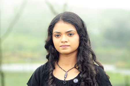 KODAIKANAL, INDIA - 30 JUNE, 2015: Cute young woman with beautiful smile posing near the pond.のeditorial素材