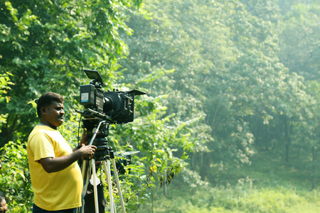 KODAIKANAL, INDIA - JUNE 21, 2016: Video camera operator on nature background, film shooting spotのeditorial素材