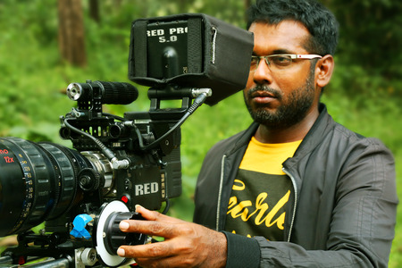KODAIKANAL, INDIA - JUNE 29TH, 2015: A man shooting at nature backgroundのeditorial素材