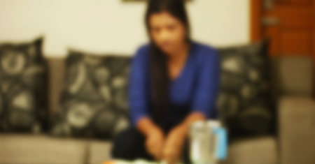 Blurry woman sitting on sofa and working.の写真素材