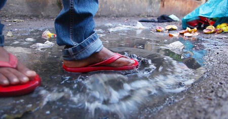 Slum area, Young man splashing in dirty water in the countryside.の写真素材