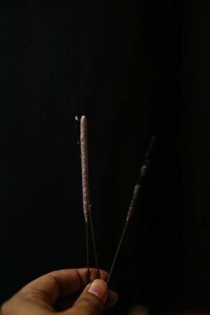 Hand Holding Extinguished Bright fireworks on a black backgroundsの写真素材