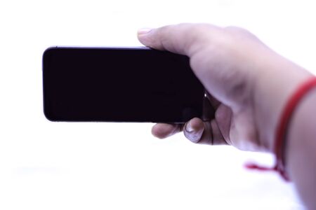 Isolated female hand holding a phone with white backgroundsの写真素材