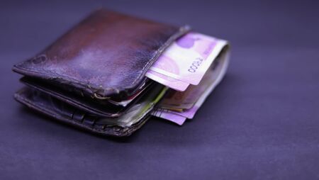 men's purse with Indian currency note inside on the black backgrounds