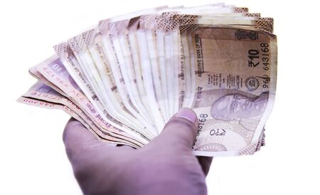 Hand with Indian ten rupee notes, white backgrounds