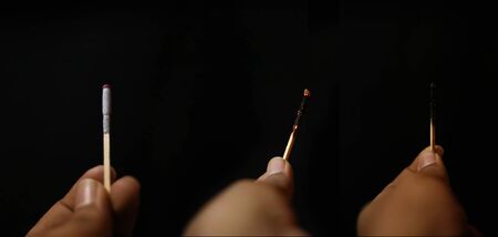 Hands holding three matchsticks on an isolated black backgrounds