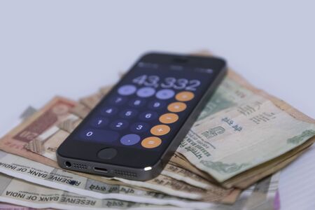 Mobile Phone and new Indian rupees banknotes on white background with space for textの写真素材