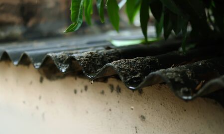 Rain drops falling from house roofの写真素材