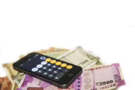 Mobile Phone and new Indian rupees banknotes on white backgroundの写真素材