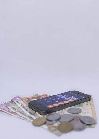 Mobile Phone Calculate and new Indian rupees blur on white background with space for textの写真素材