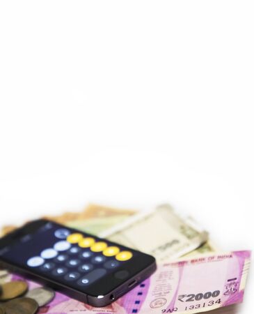 Finance concept - Mobile Phone Calculate and new Indian rupees blur on white backgroundの写真素材