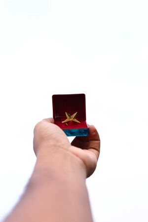 The Christmas star gift box on hand is isolated on a white backgrounds