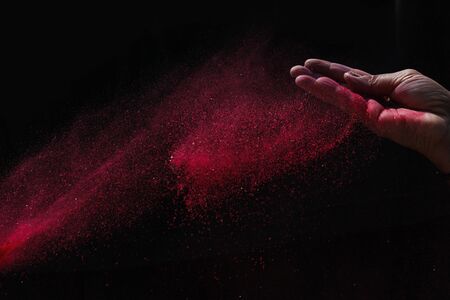 Indian woman hand colourful holi powder splash at black backgroundsの写真素材
