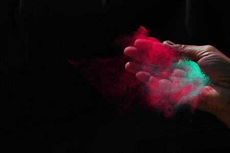 Indian woman hand colourful holi powder splash at black backgroundsの写真素材