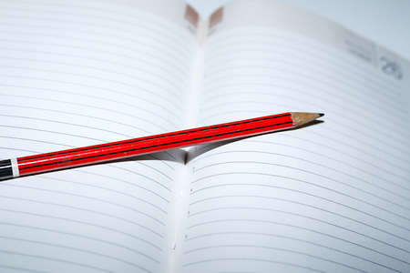 close up shot of blank paper daily notebook page with pencilsの写真素材