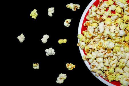 Spilled popcorn on a black background, cinema, movies and entertainment concepts