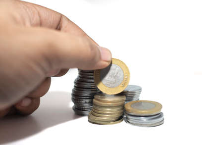 Hand with Indian currency coins isolated on white backgrounds