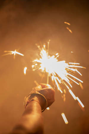 A selected focus shot of an Indian woman holding a firecrackerの写真素材