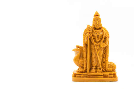 The hand-carved wooden statue of Lord Murugan is isolated on a white backgrounds