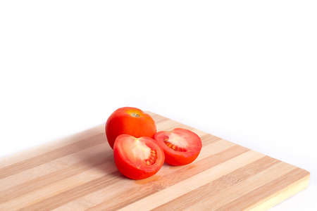 chopped tomatoes on cutting board isolated on the white backgrounds.の写真素材