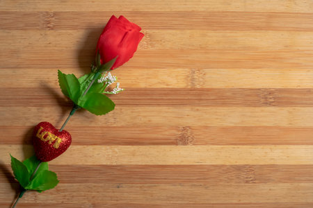 Valentine's Day background with a Red plastic roses on a wooden table for the concept of love.の写真素材