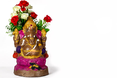 Happy Ganesh Chaturthi - Beautiful Ganesh statue made of clay with flowers on white background.の写真素材