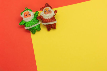 Santa claus and elf on red and yellow background with copy spaceの写真素材